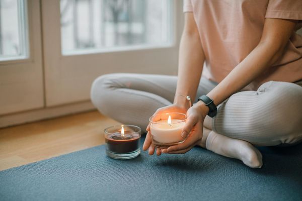 Elegant yoga mat with a lit candle in a dark room.