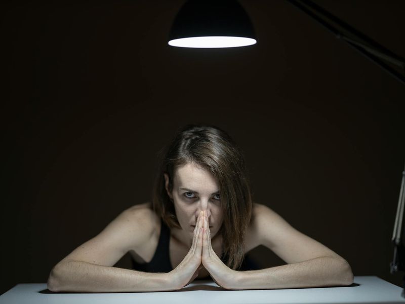 Woman hands in a prayer pose with ruby light.